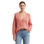 Woman wearing a pink cardigan and blue jeans on a white background